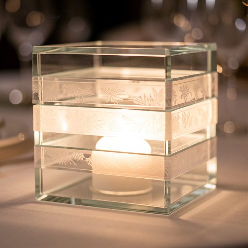 Effet photophore élégant sur un motif de calque, avec verre superposé et lueurs chaudes, rendu photo réaliste et lumineux.